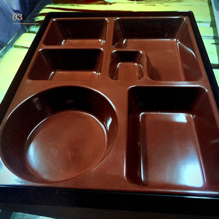 An approved golden sample: a molded red and black compartment tray
