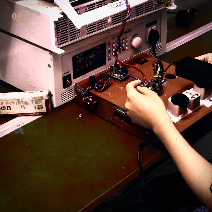 Hands connecting a circuit board to a power test station for a functional test