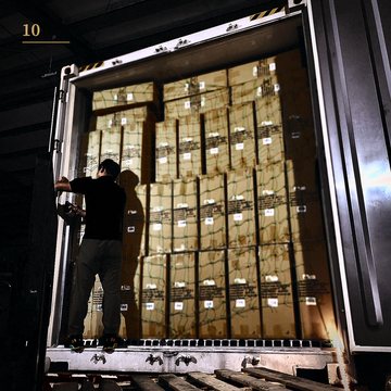 A worker loading export cartons into a shipping container