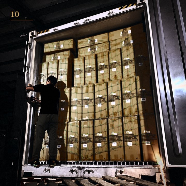 A worker loading export cartons into a shipping container