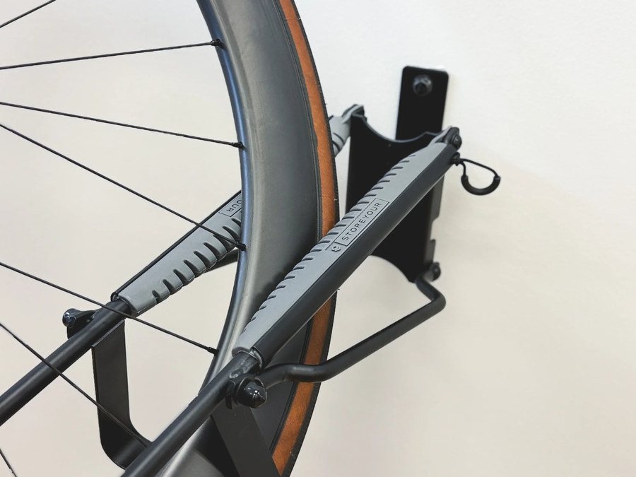 Wall-mounted bike rack holding a road bike wheel