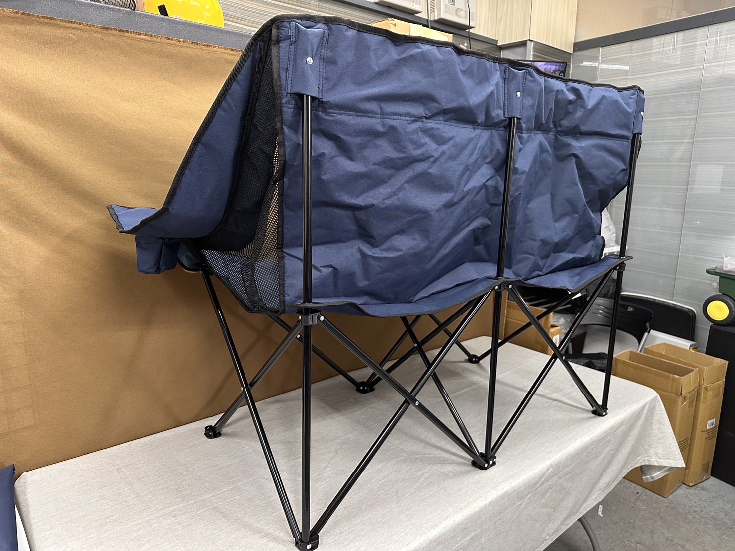 A folding chair with a patterned sling seat and wood-and-metal frame