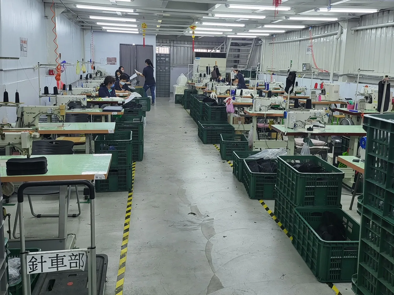 Rows of industrial sewing machines on a partner factory floor