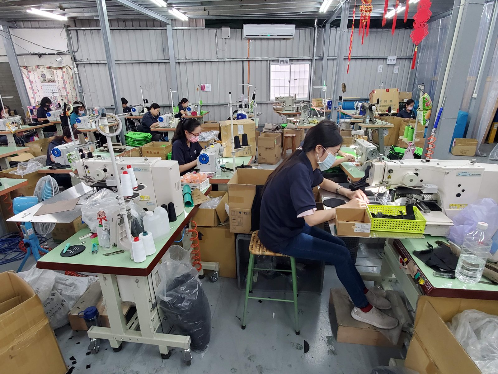 A cut-and-sew production line at a qualified partner factory, operators at industrial sewing machines