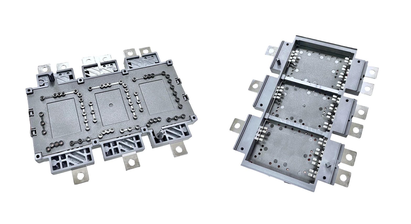 Two gray insert-molded plastic housings with rows of metal terminals and threaded inserts, shown top and bottom on a white background