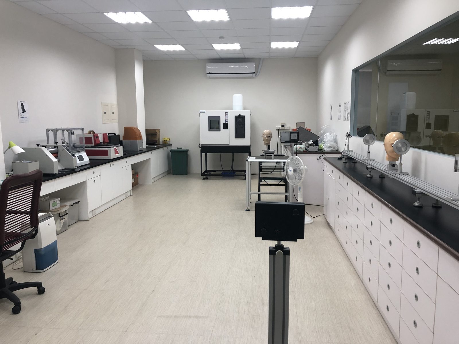 A product test lab with bench instruments, an environmental test chamber and head forms on the counters