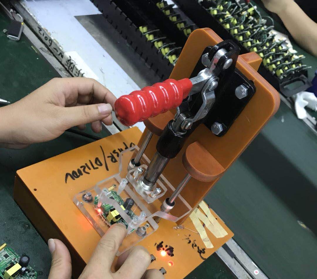 An operator clamping a circuit board into a hand-built test fixture