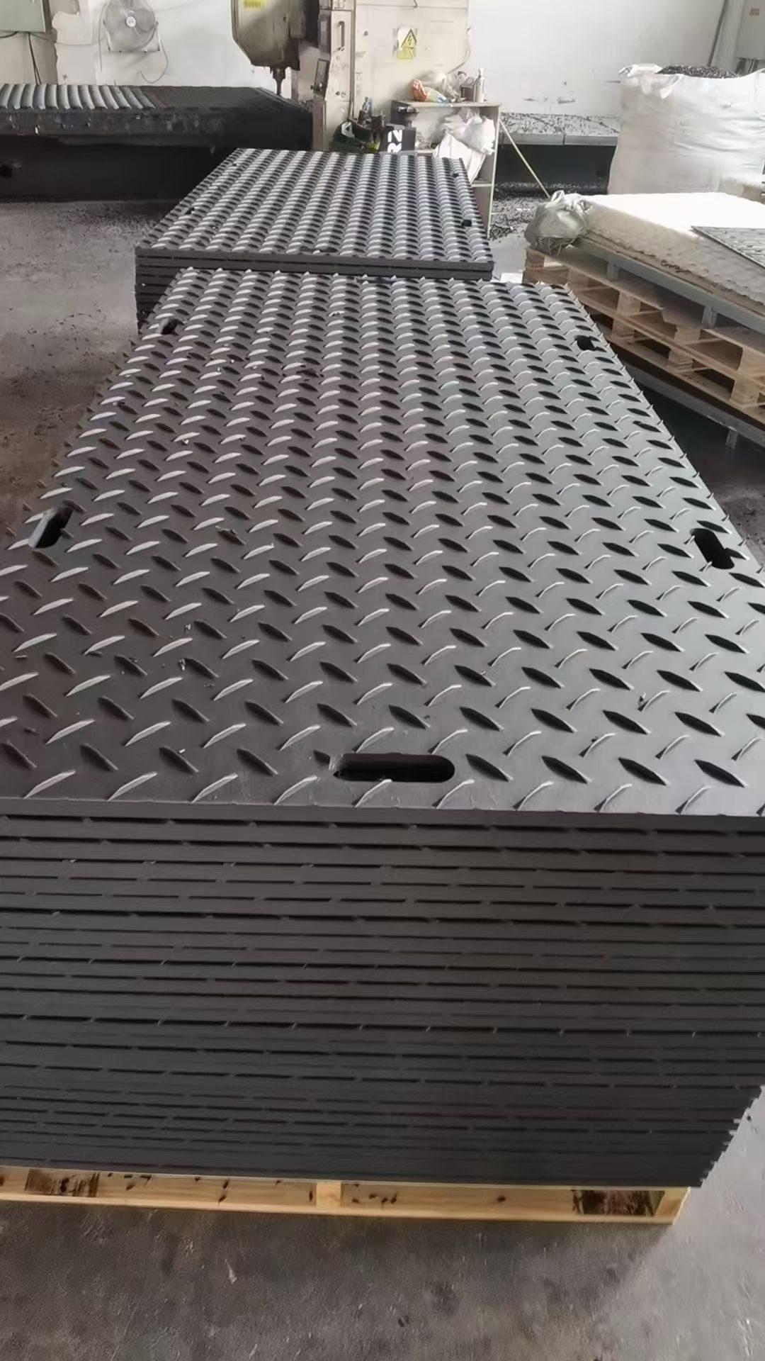 A pallet of black treaded ground protection mats, finished goods waiting to be shipped and assessed for US import duty