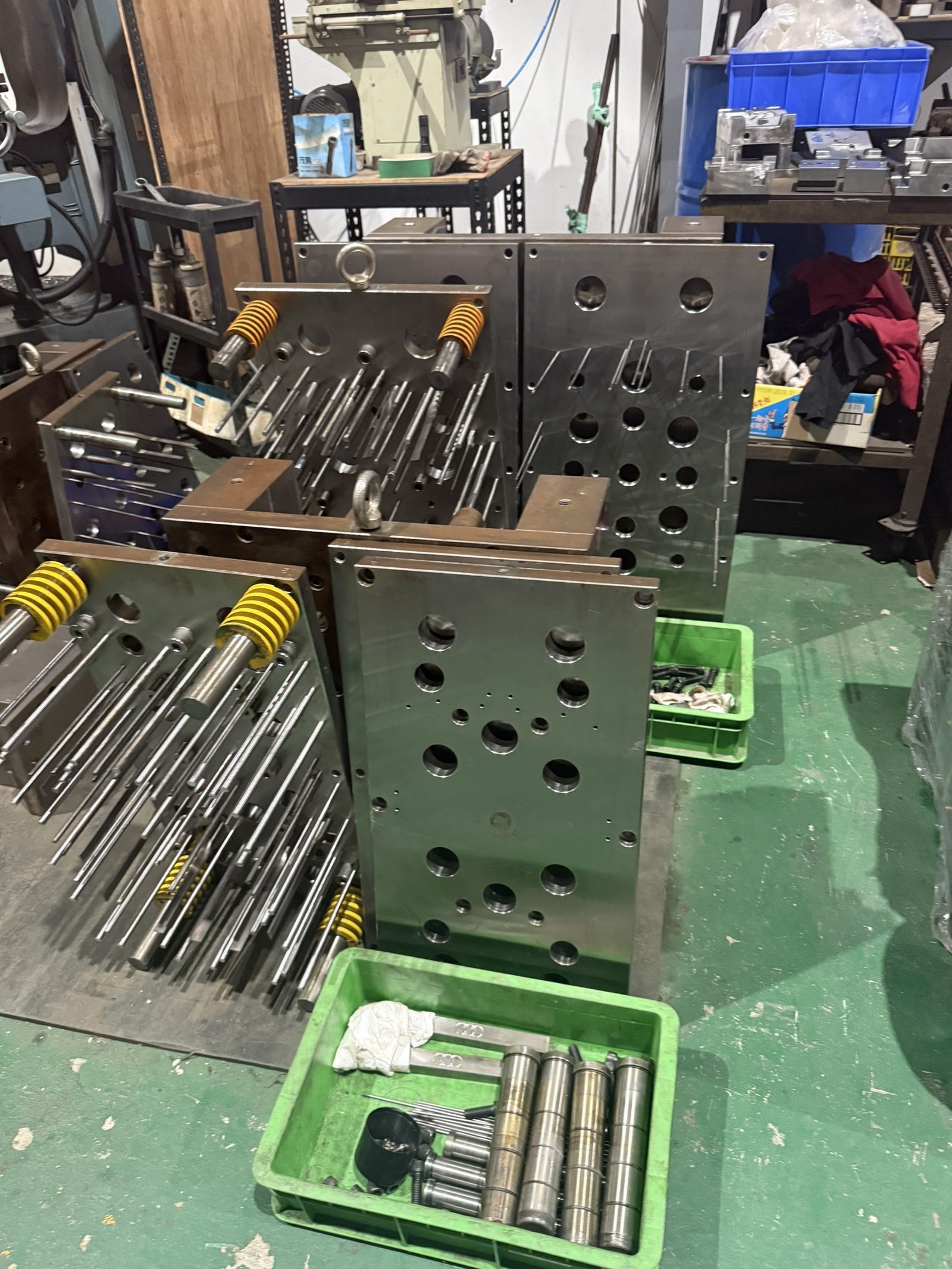 Injection mold ejector plates, ejector pins and return springs taken apart in a toolroom