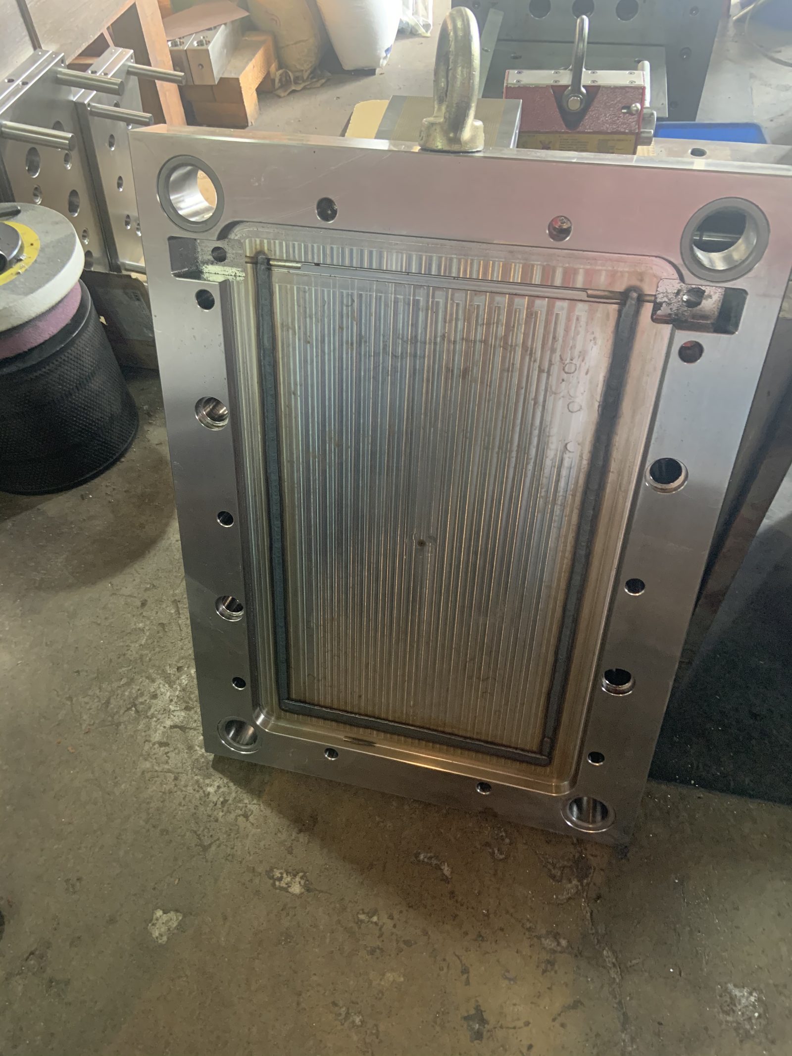 Hardened steel injection mold cavity plate standing on the floor of a toolroom in Tainan, Taiwan