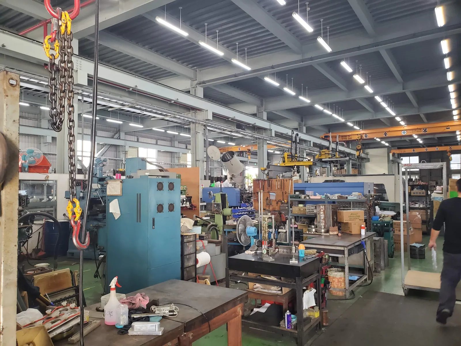 The floor from the gangway — presses, benches and material stacked down the length of the hall.