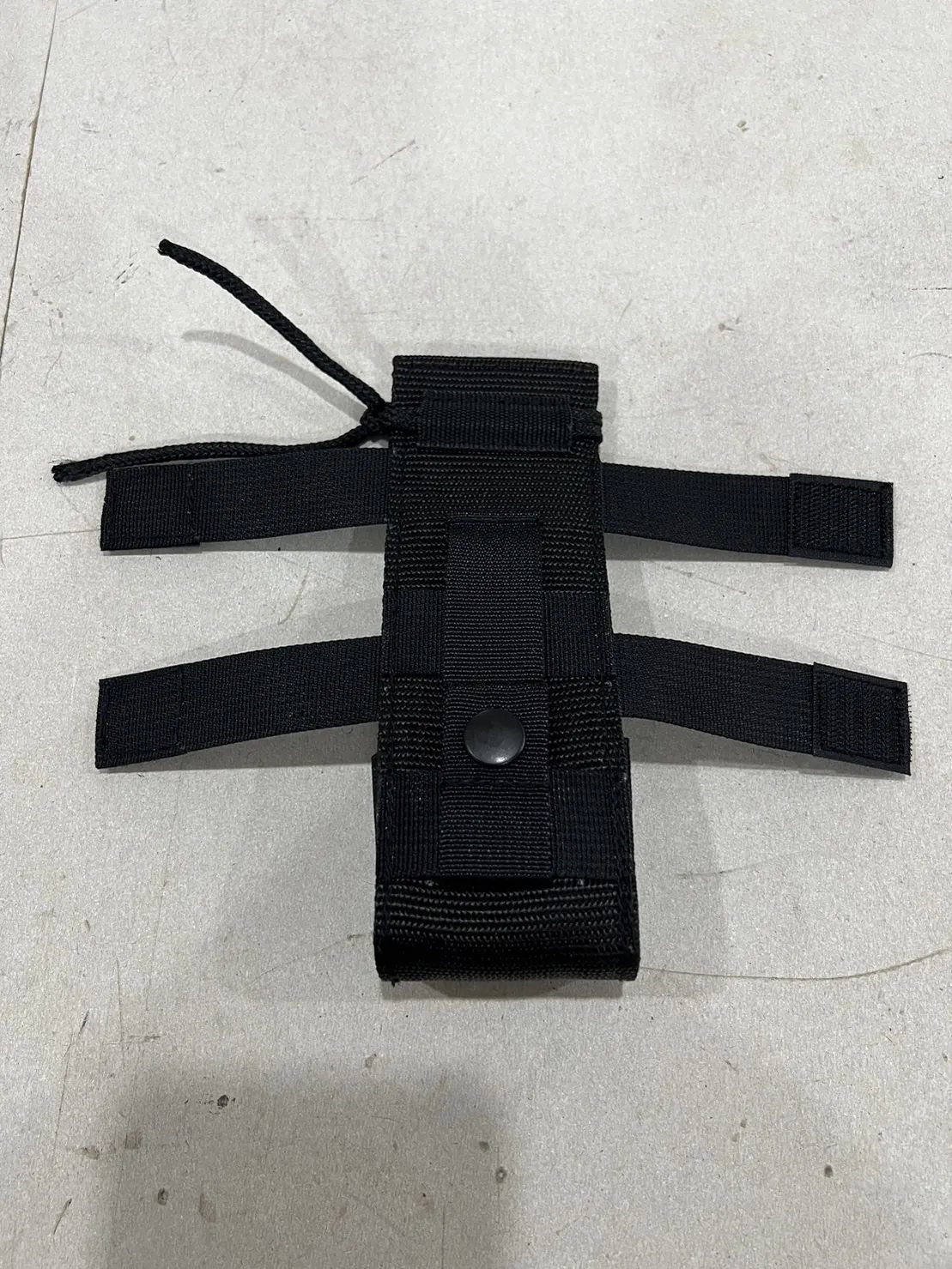 A sewn webbing carrier, finished and laid flat.