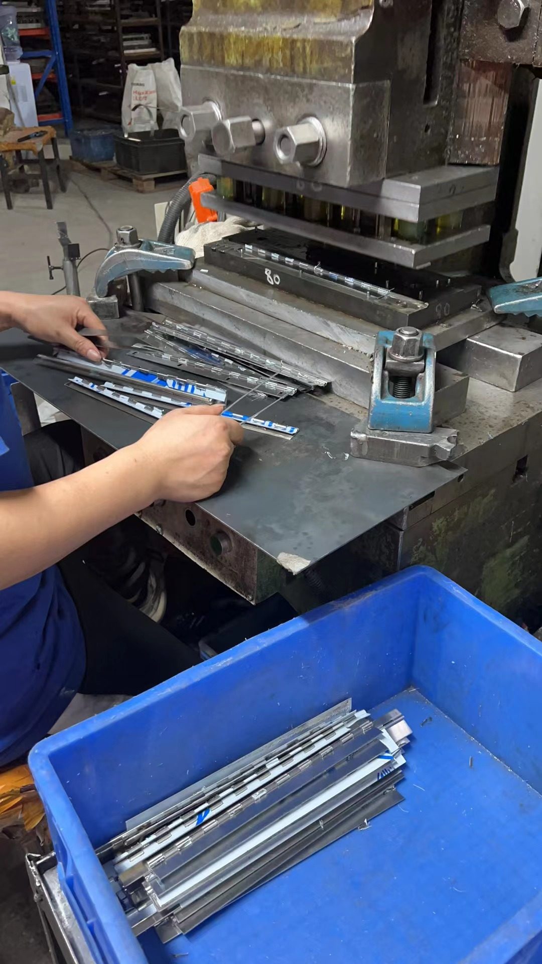 Press work. Hands on the job — a person on Jack's assembly path.