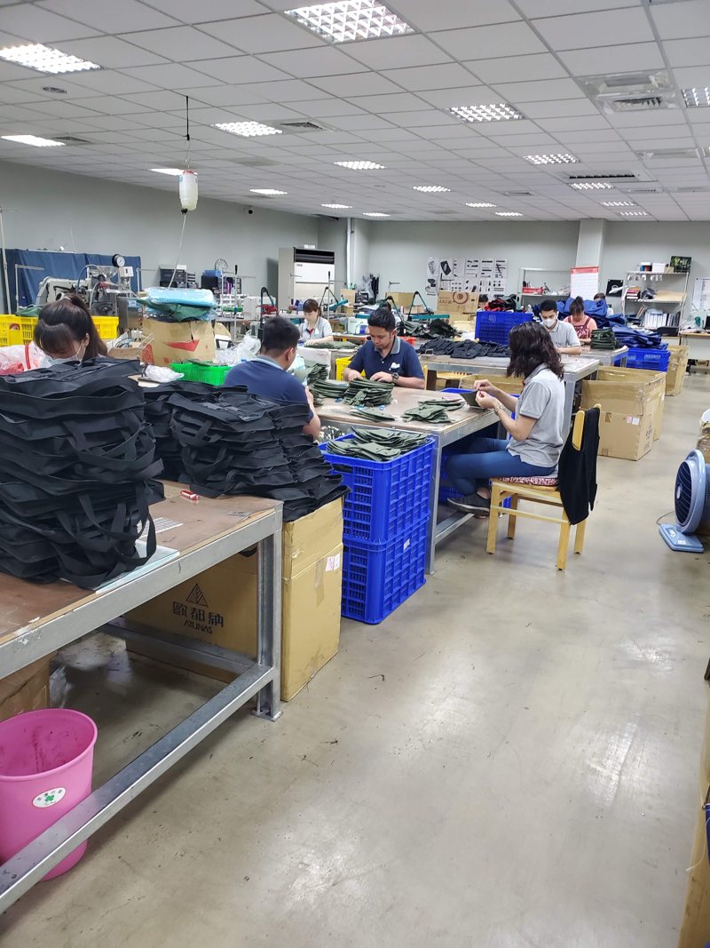 A large sewing floor with rows of machines and operators