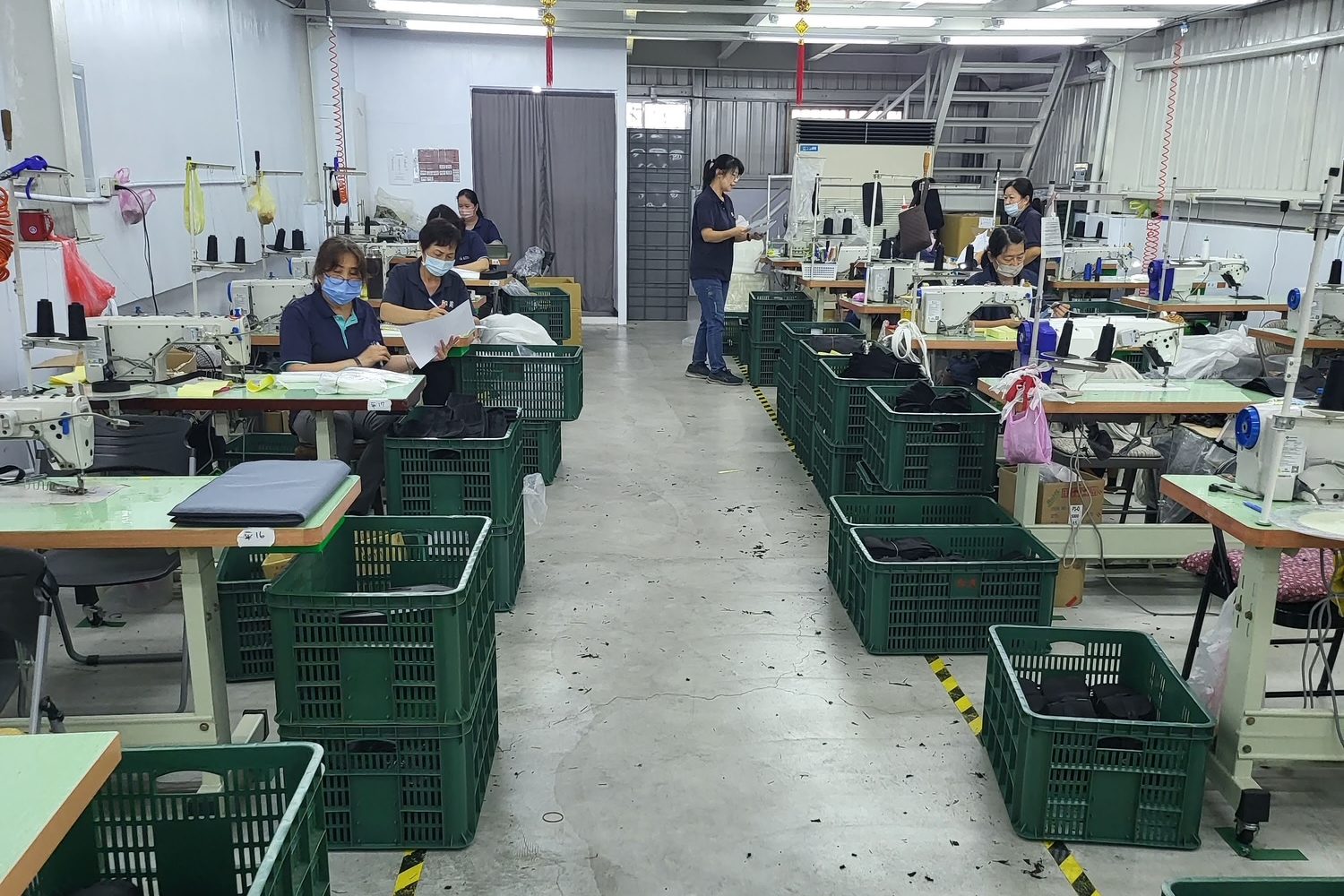 A cut-and-sew line in Taiwan: sewing stations down both sides of a center aisle, with bins of cut parts