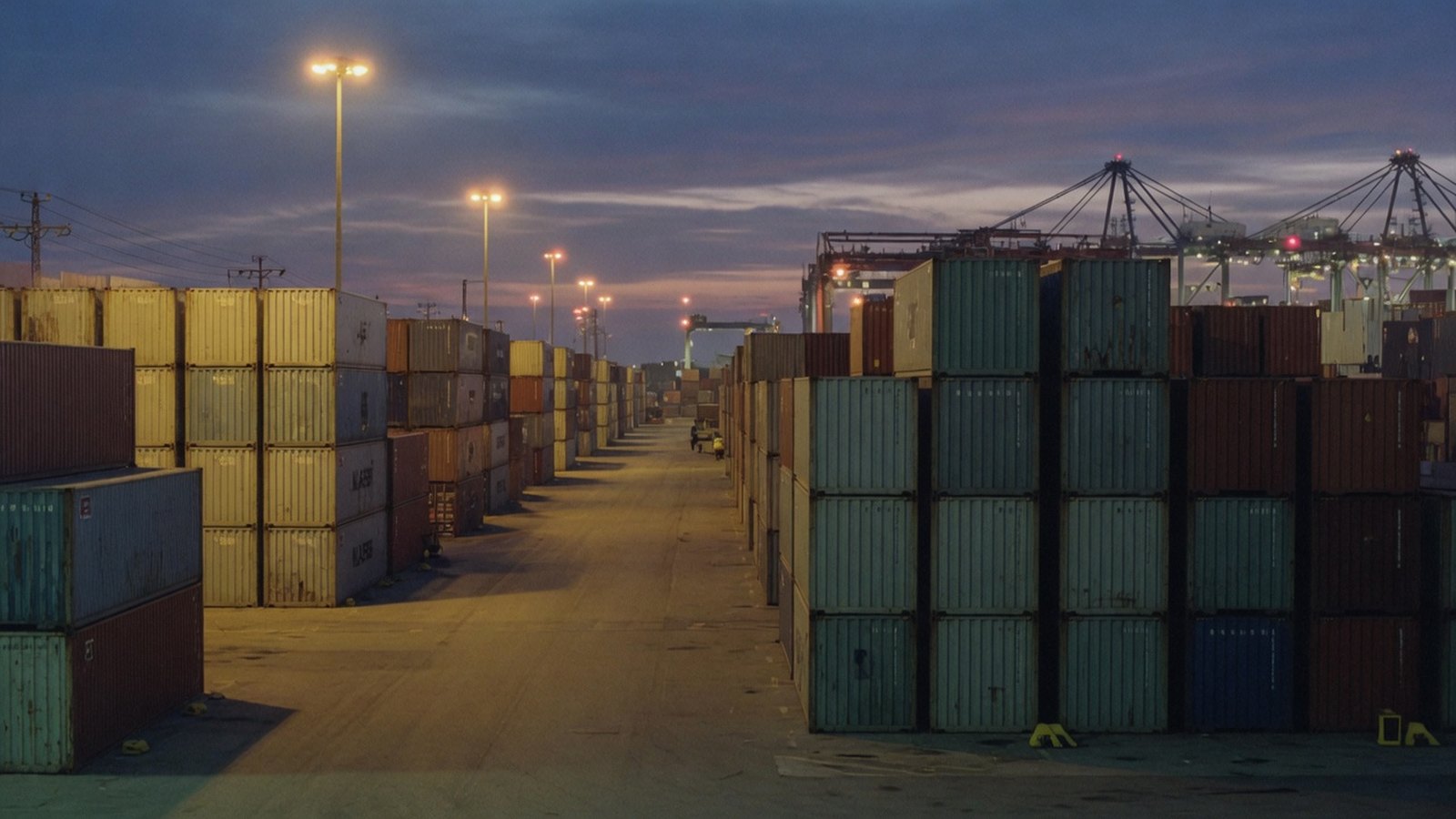 Container stacks at a port at dusk