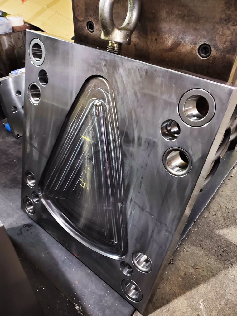 One half of an injection mold, cavity face up on the stand
