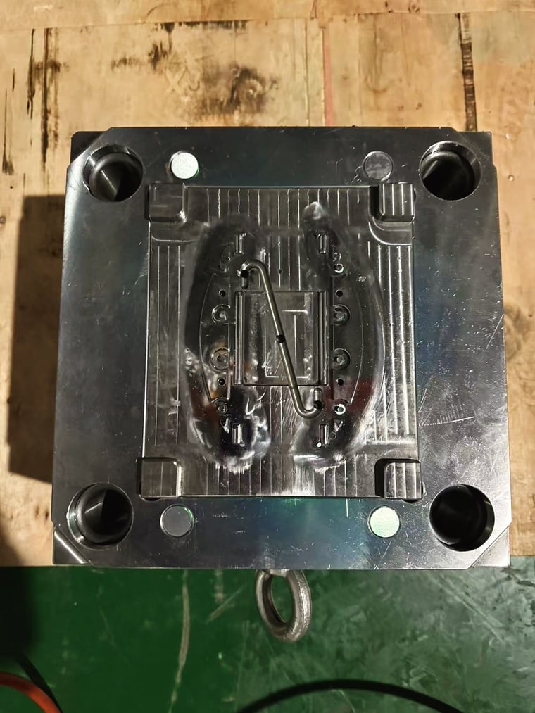 An opened injection mold on the bench, cavity side up