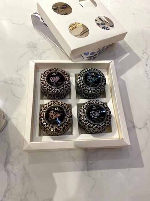 A white window gift box holding four printed caviar tins