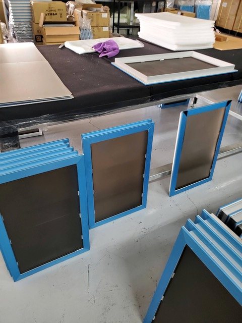 Aluminum door frames staged on the bench before assembly.