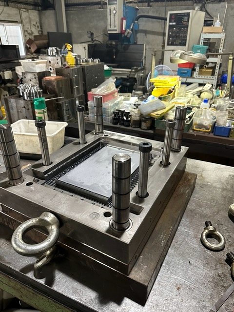 A tool on the bench with its guide pins and lifting eyes.