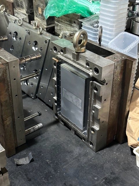 A tool opened up on the floor, core and cavity sides apart.