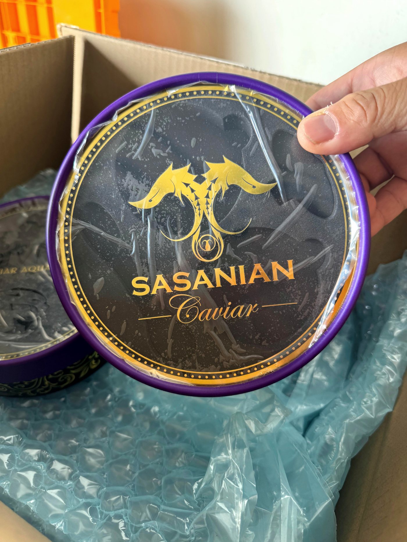 A printed caviar tin wrapped in bubble film inside a shipper