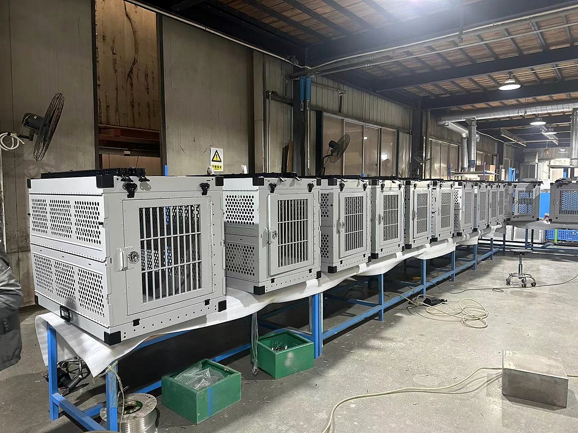 A line of aluminum crates in assembly on a factory floor