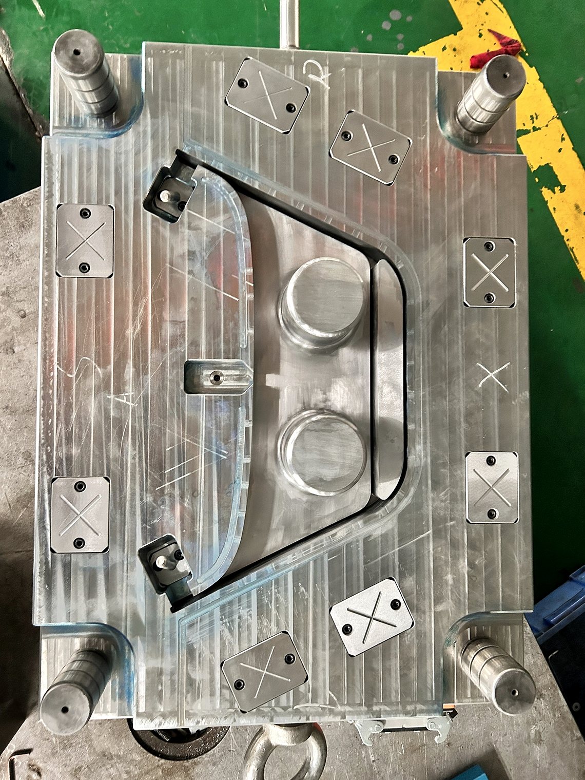 A machined mold plate on the shop floor: cavity pocket, guide pillars and lifting points